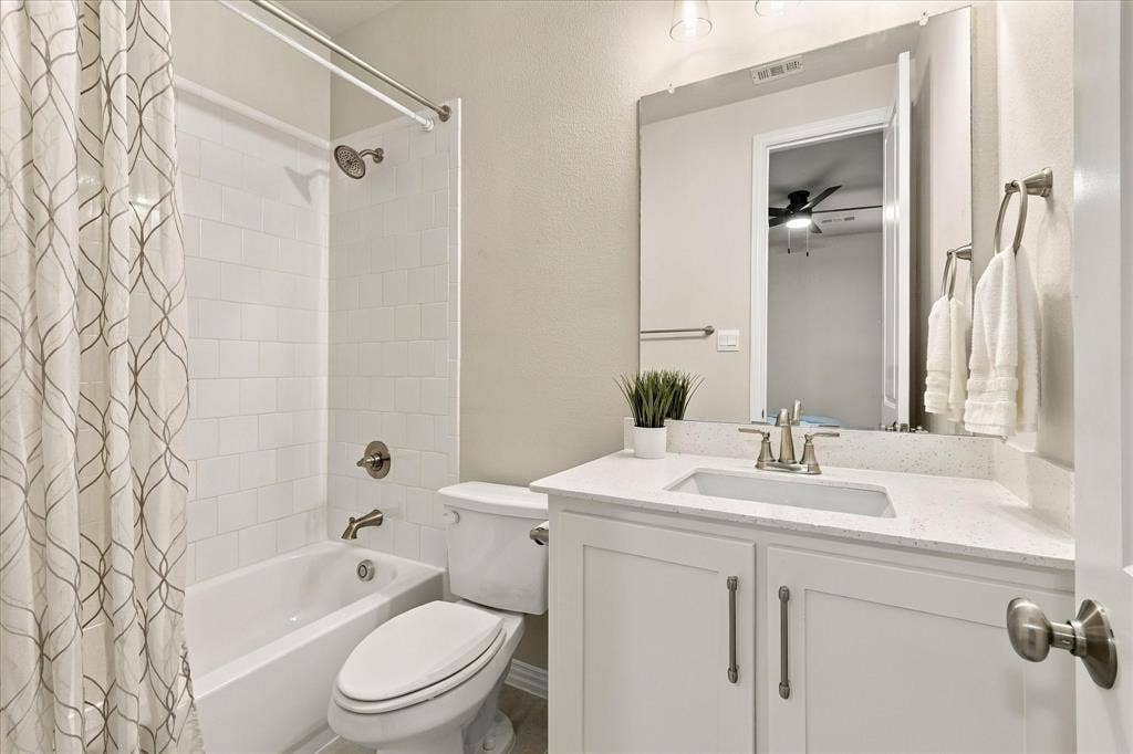 White vanity with dual cabinet doors, light-colored countertop, undermount sink, brushed nickel faucet, and a large mirror