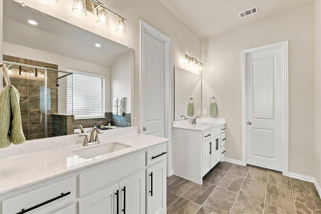 Dual vanity with white cabinetry, polished chrome fixtures, and quartz countertops