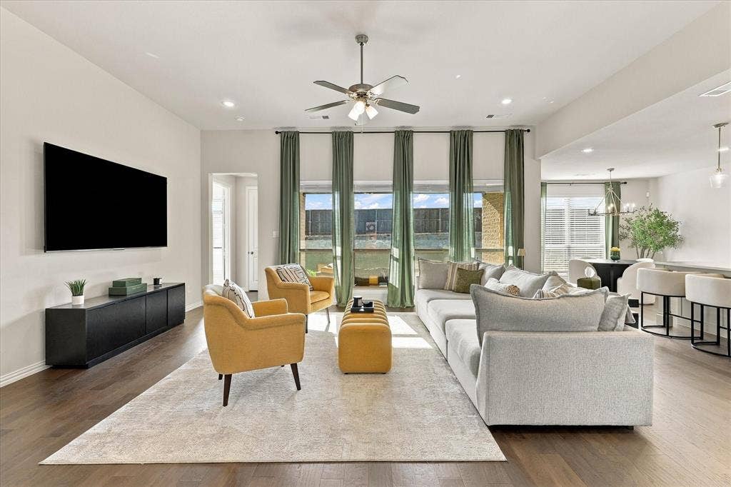 High ceilings, wood-finish flooring, recessed lighting, ceiling fan, and extensive window treatments