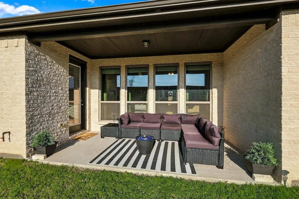 Covered patio featuring a concrete surface, overhead lighting, and multiple windows