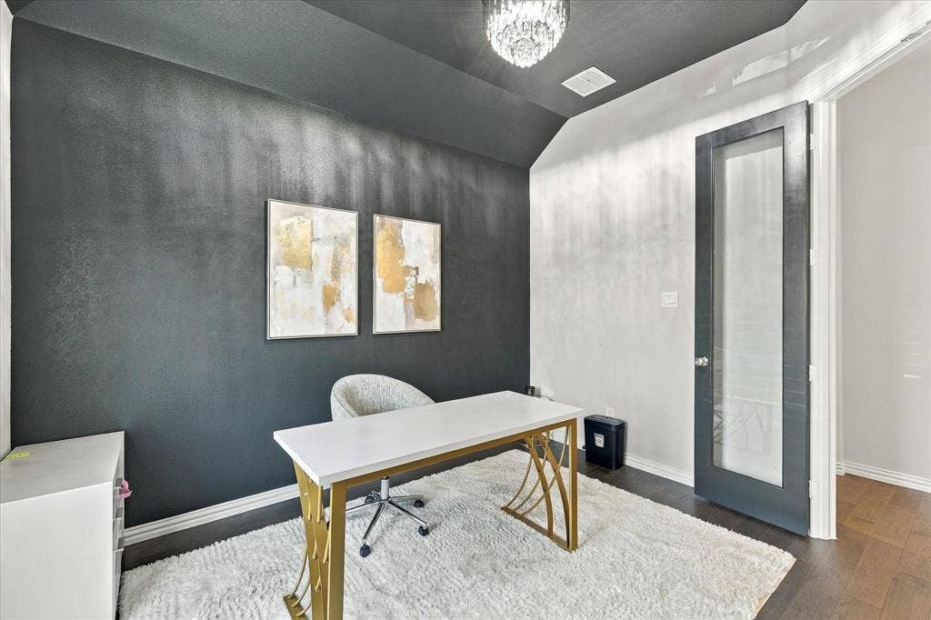 Vaulted ceiling with a chandelier, dark wood-finish flooring, and a glass-paneled door
