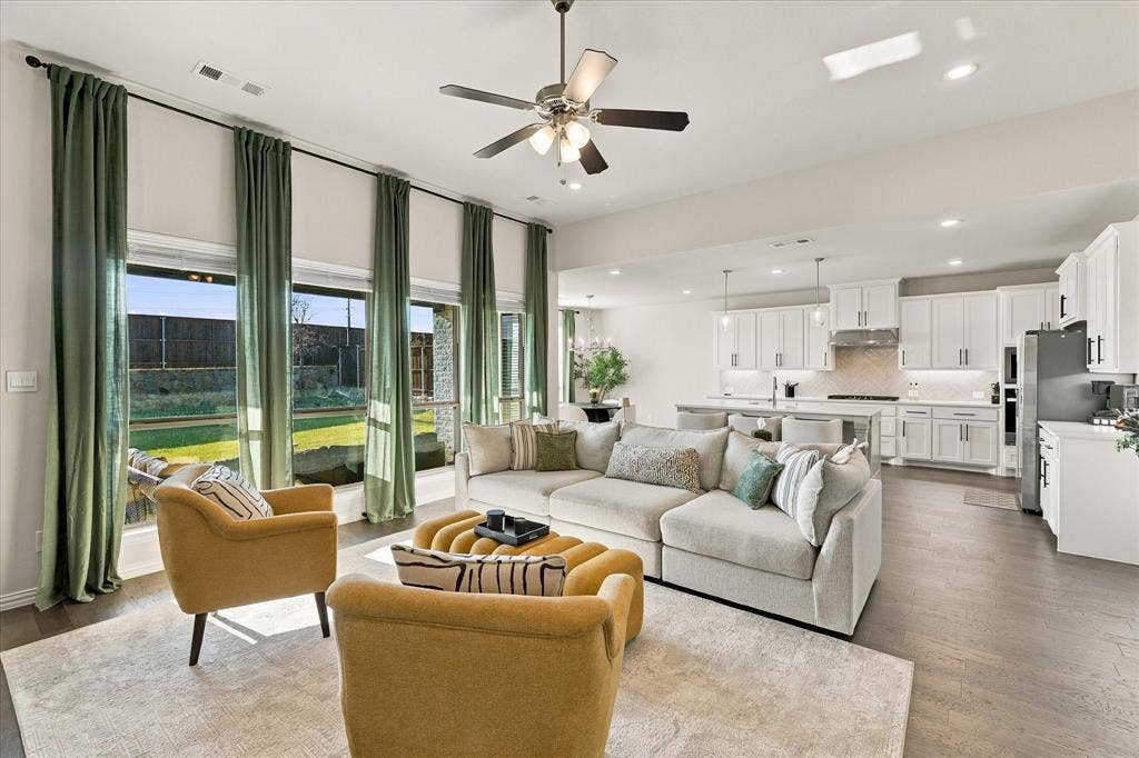 Open-concept living area with wood-finish flooring, a ceiling fan, and recessed lighting