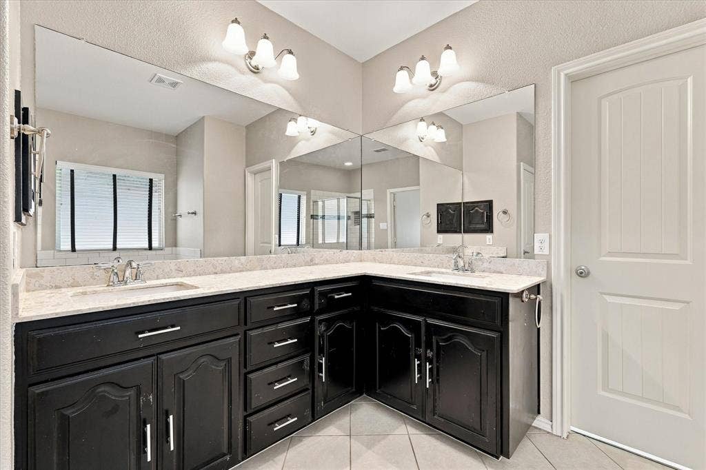 4716 Kendrick Peak Way, Fort Worth, TX 76244 Dual vanity with stone-look countertops, dark wood-finish cabinetry, and brushed nickel hardware