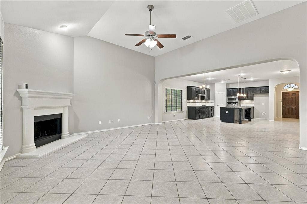 4716 Kendrick Peak Way, Fort Worth, TX 76244 Spacious room featuring vaulted ceilings, a built-in fireplace with a mantel, and tiled flooring