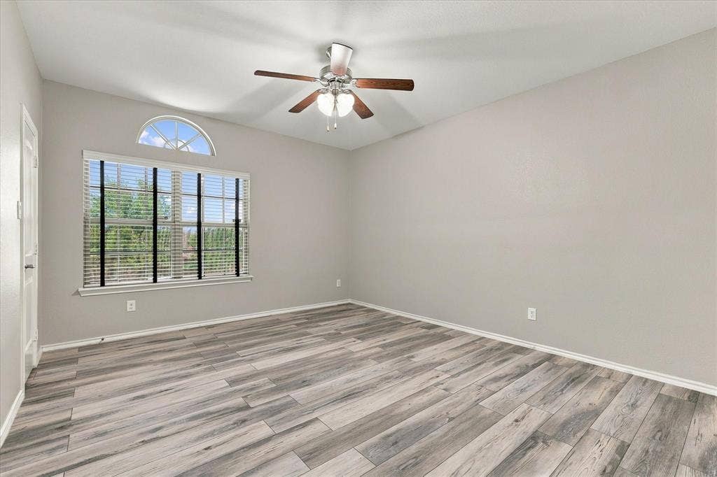 4716 Kendrick Peak Way, Fort Worth, TX 76244 Vaulted ceiling with a ceiling fan, wood-finish flooring, and a large window with an arched transom