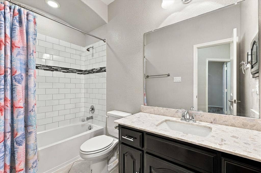 4716 Kendrick Peak Way, Fort Worth, TX 76244 Bathroom featuring a single vanity with stone-finish countertop, undermount sink, and dark wood-finish cabinetry