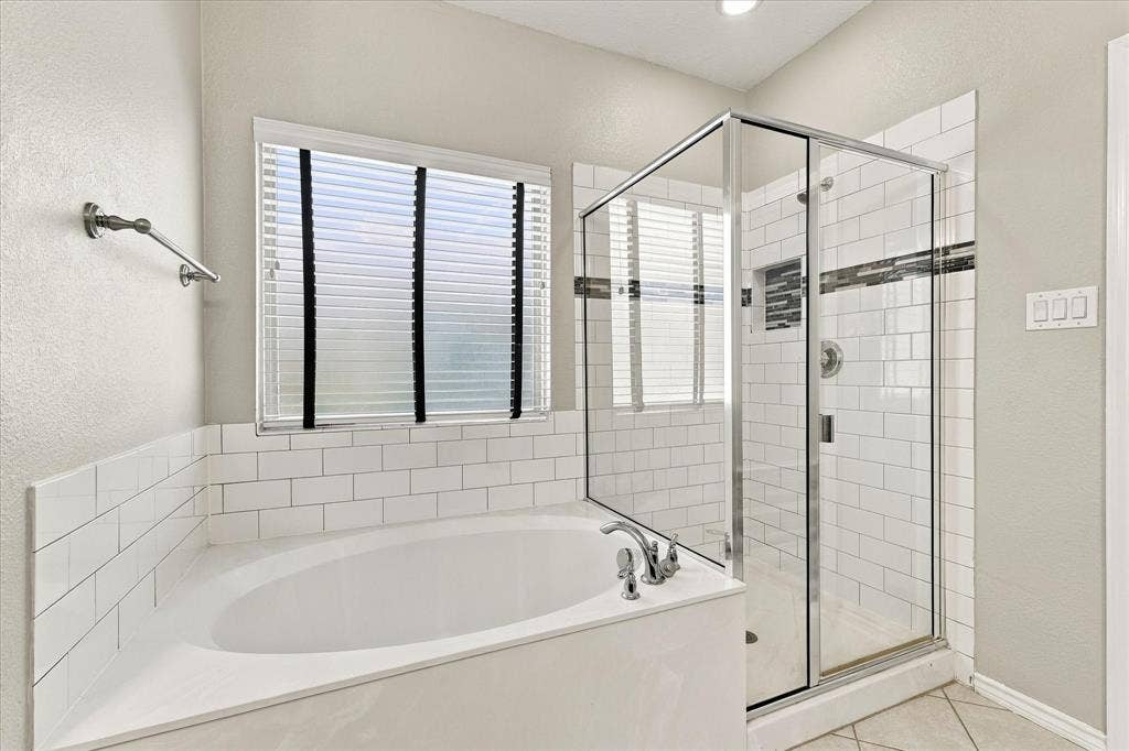 4716 Kendrick Peak Way, Fort Worth, TX 76244 Built-in soaking tub with subway tile surround, glass-enclosed shower with subway tile, and tile flooring