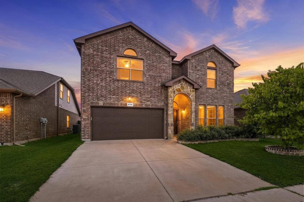 4716 Kendrick Peak Way, Fort Worth, TX 76244 Brick exterior with stone accents, arched entryway, attached garage, and landscaped front yard