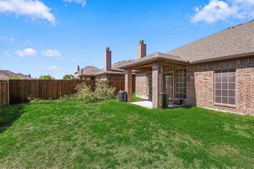 4716 Kendrick Peak Way, Fort Worth, TX 76244 Expansive green yard with a covered patio, brick exterior, and a privacy fence