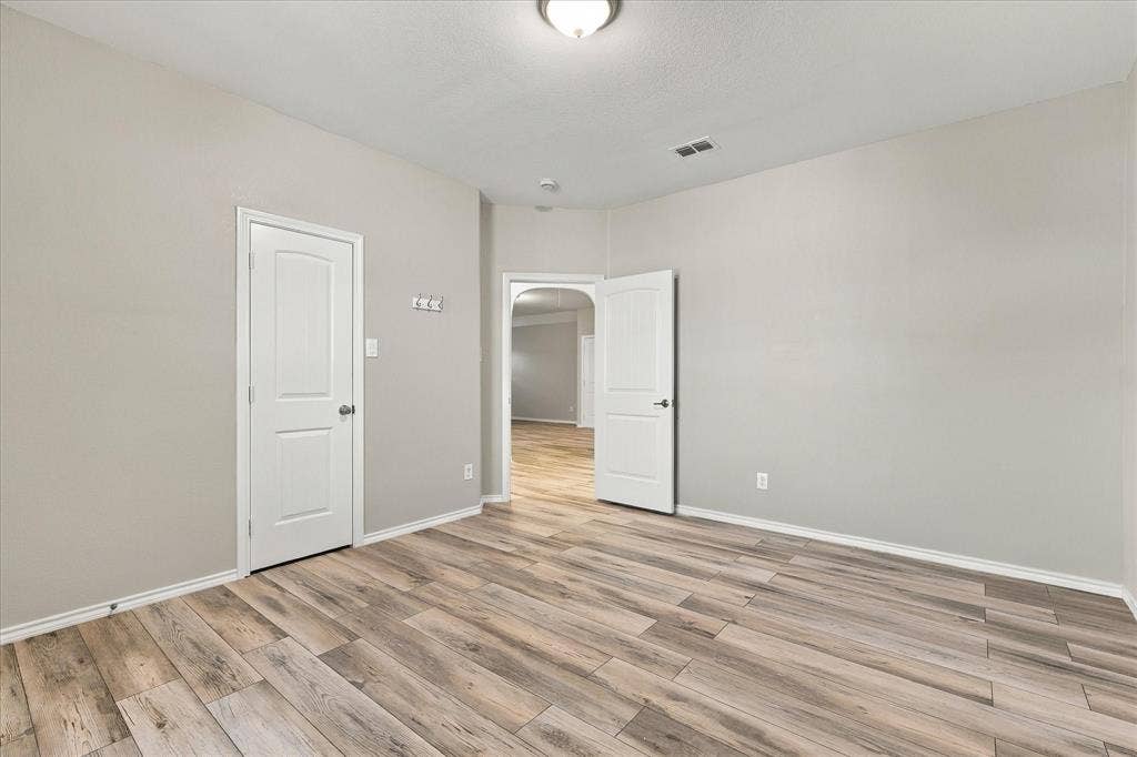4716 Kendrick Peak Way, Fort Worth, TX 76244 Neutral wall color, wood-finish flooring, white paneled doors, ceiling-mounted light fixture, recessed lighting
