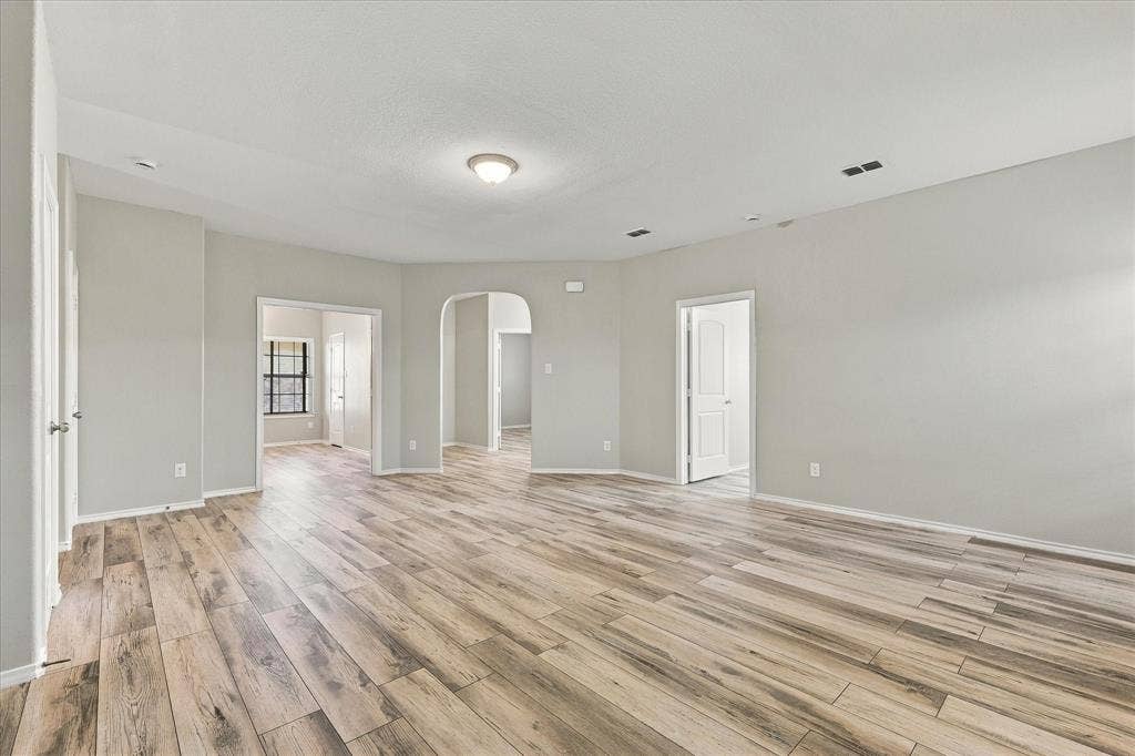 4716 Kendrick Peak Way, Fort Worth, TX 76244 Wood-finish flooring, light gray wall paint, white trim, recessed lighting, and arched doorways