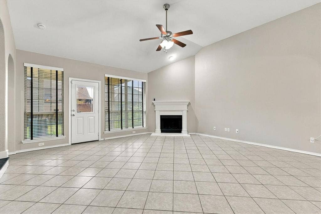 4716 Kendrick Peak Way, Fort Worth, TX 76244 Vaulted ceiling, ceramic tile flooring, ceiling fan with light fixture, white fireplace with mantel, and direct outdoor access