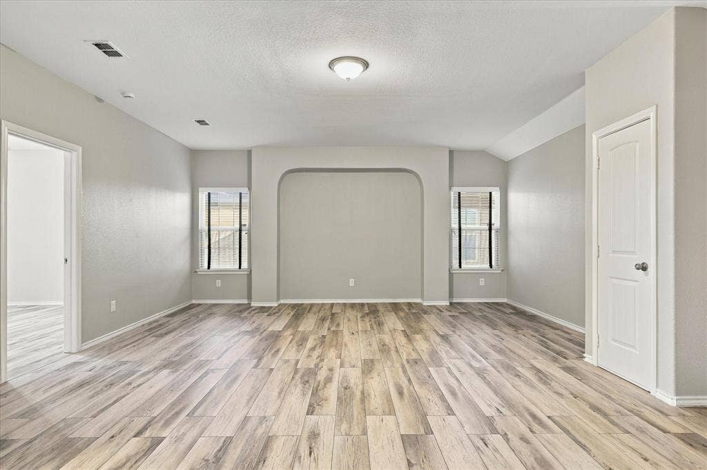 4716 Kendrick Peak Way, Fort Worth, TX 76244 Wood-finish flooring, recessed archway, two windows with sills, white interior doors, and a ceiling-mounted light fixture