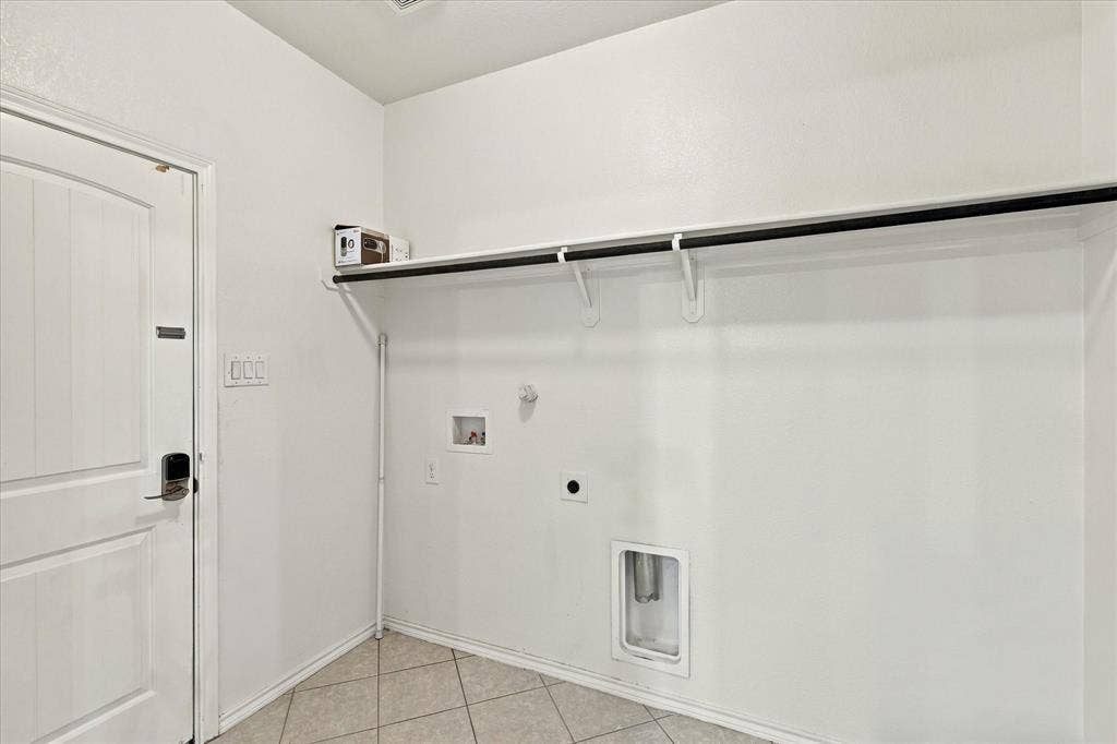 4716 Kendrick Peak Way, Fort Worth, TX 76244 Utility area featuring a built-in hanging rod, overhead shelving, and neutral tile flooring