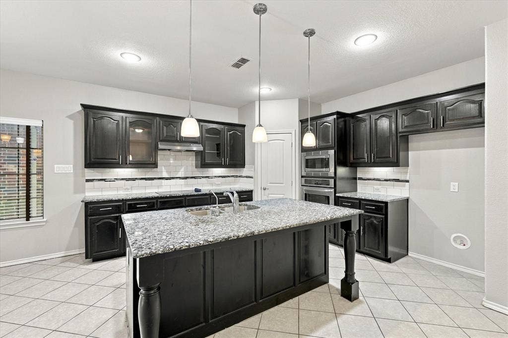 4716 Kendrick Peak Way, Fort Worth, TX 76244 Central island with a granite countertop and undermount sink