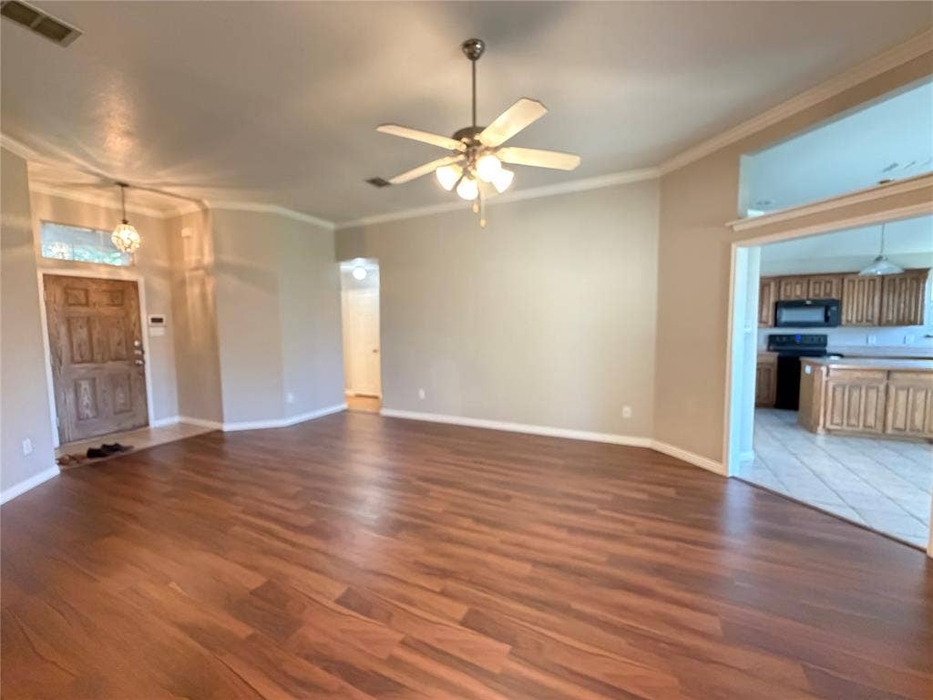 5932 Highcrest Drive, Watauga, TX 76148 Wood-finish flooring, crown molding, ceiling fan, recessed lighting, and a paneled entry door