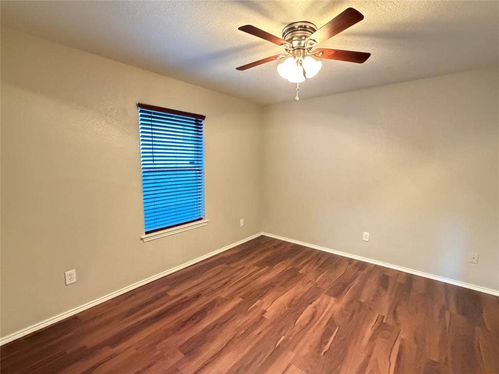 5932 Highcrest Drive, Watauga, TX 76148 Wood-finish flooring with white trim, window with blinds, and a ceiling fan with integrated lighting