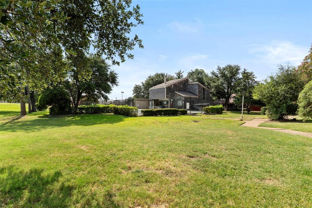 4414 Westminster Drive, Irving, TX 75038 Expansive lawn area with mature trees and a paved walkway