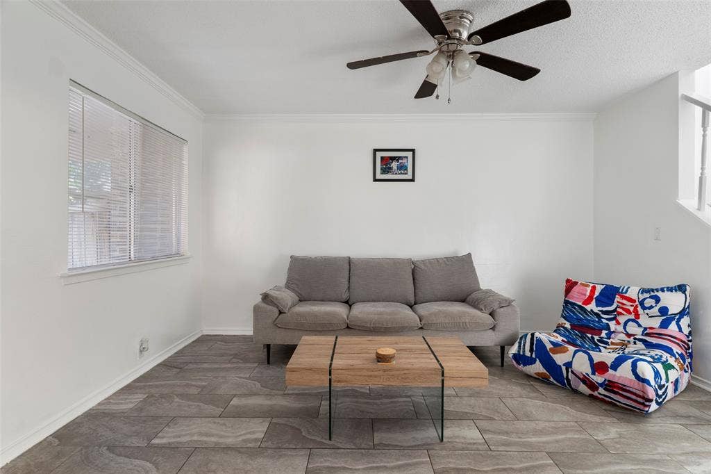 4414 Westminster Drive, Irving, TX 75038 Spacious room featuring durable tile flooring, crown molding, and a ceiling fan with light fixture