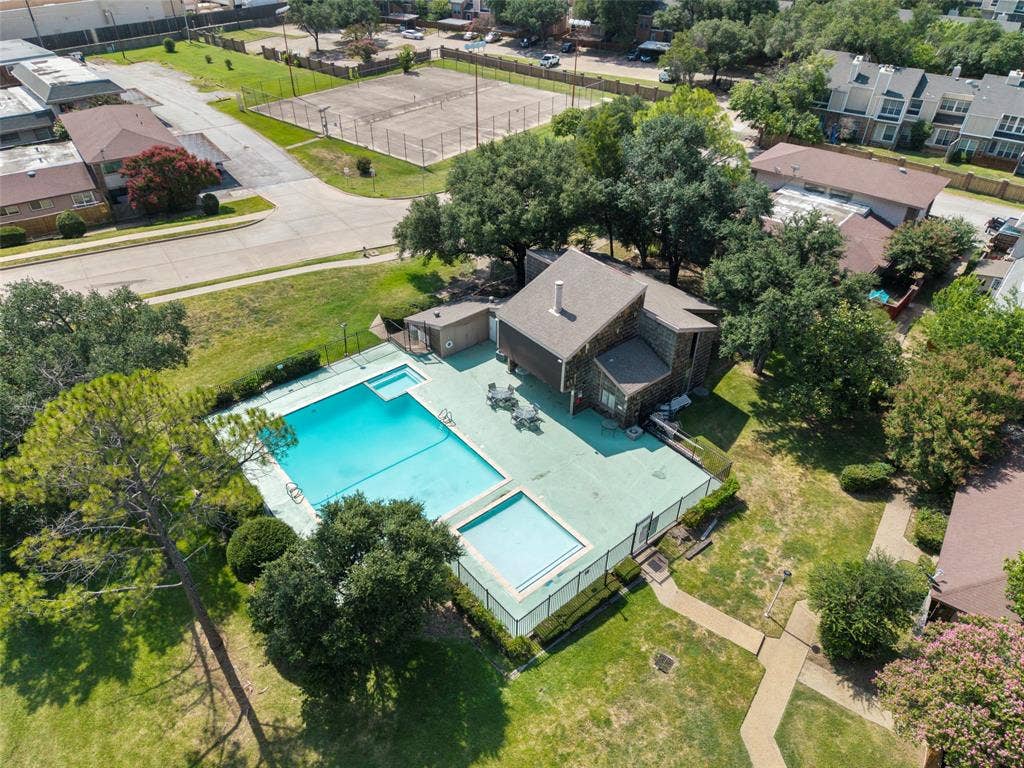 4414 Westminster Drive, Irving, TX 75038 Resort-style saltwater swimming pool with sun deck and shallow lounging area, surrounded by mature landscaping and lush lawn