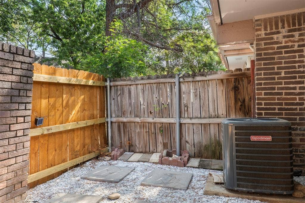 4414 Westminster Drive, Irving, TX 75038 Brick exterior with a Goodman HVAC unit and a wood privacy fence