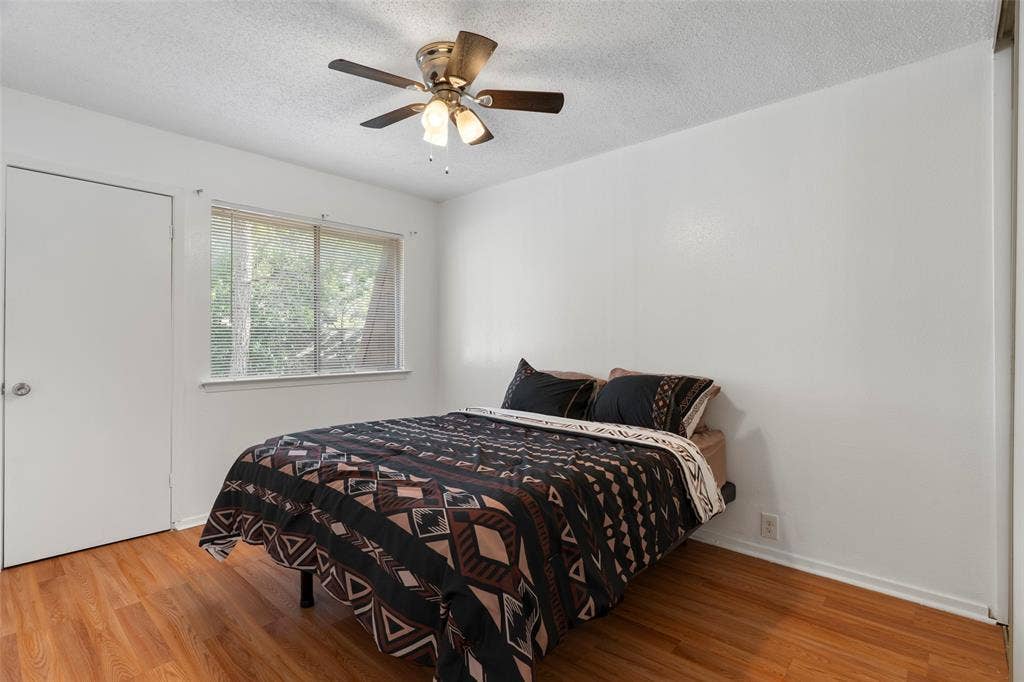 4414 Westminster Drive, Irving, TX 75038 Wood-finish flooring, white walls, and a window with blinds