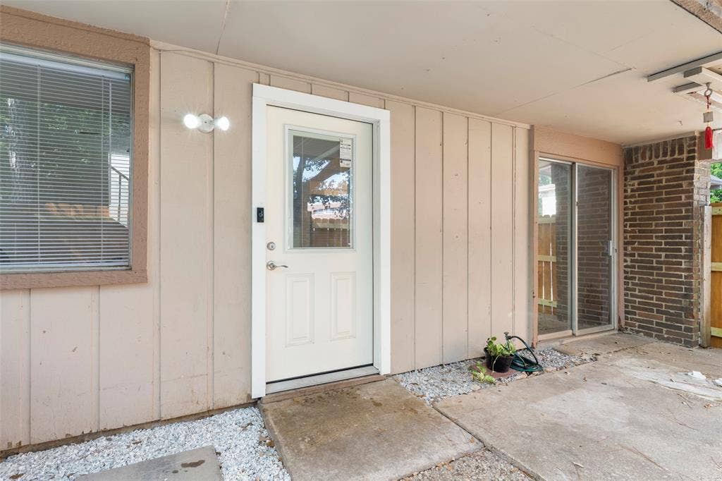 4414 Westminster Drive, Irving, TX 75038 Covered patio featuring concrete flooring, a white paneled door with glass insert, and a sliding glass door