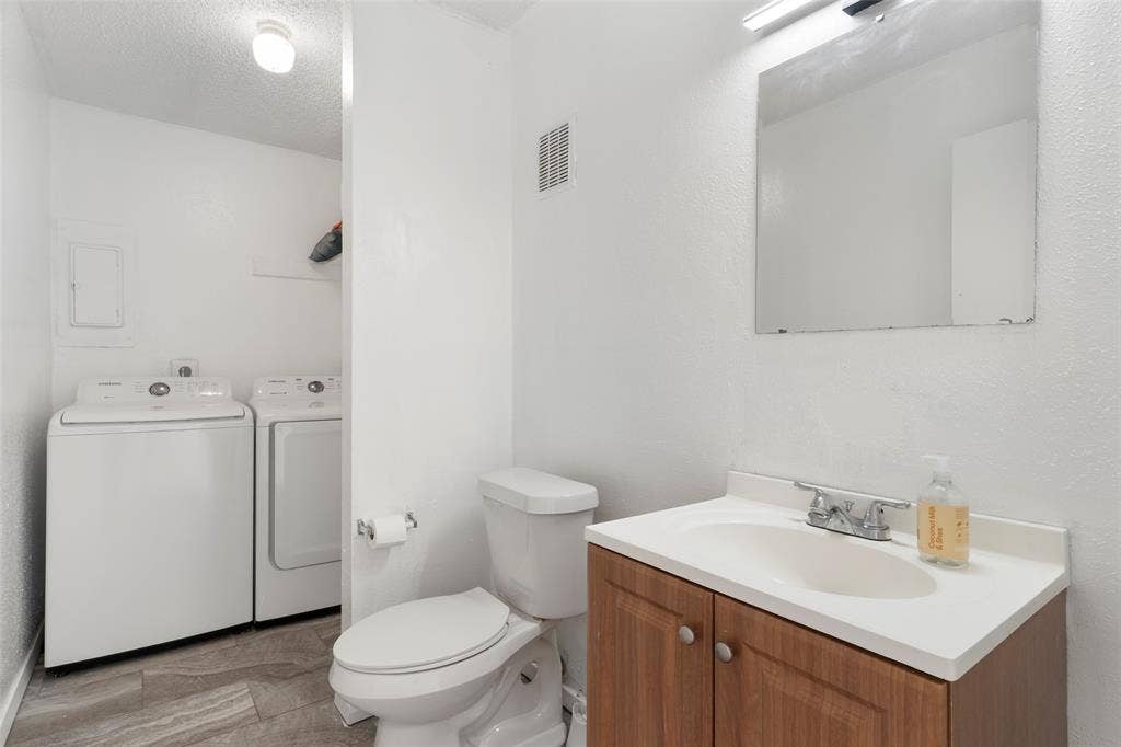 4414 Westminster Drive, Irving, TX 75038 Wood-finish vanity with a white countertop and integrated sink