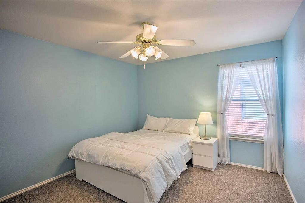 1950 Garrison Way, Garland, TX 75040 Soft blue wall finish with a white ceiling, featuring a ceiling fan with integrated lighting