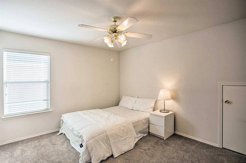 1950 Garrison Way, Garland, TX 75040 Textured carpeting, a single window with blinds, a ceiling fan with integrated lighting, and a white interior door with a brass-finish knob