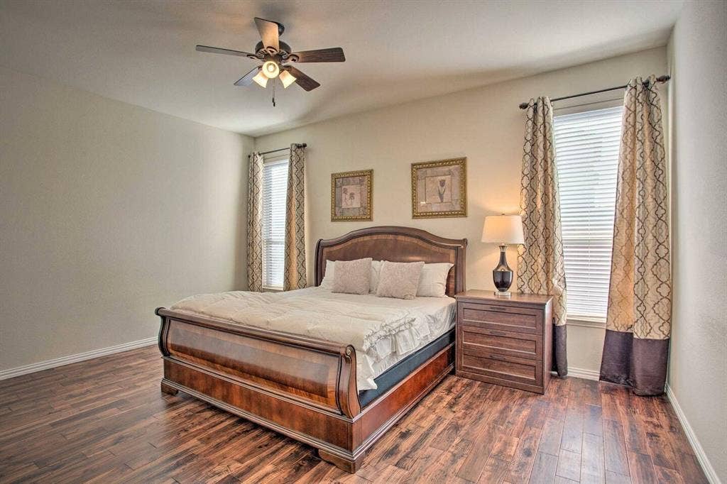 1950 Garrison Way, Garland, TX 75040 Wood-finish flooring, ceiling fan with integrated lighting, and two windows with blinds