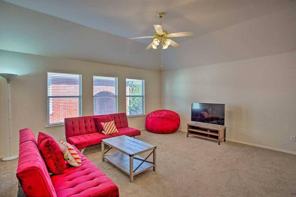 1950 Garrison Way, Garland, TX 75040 Carpeted living area with vaulted ceiling, ceiling fan with light fixture, and three windows