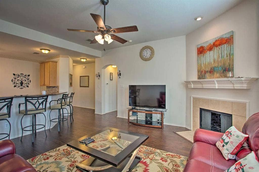 1950 Garrison Way, Garland, TX 75040 Living area featuring wood-finish flooring, a ceiling fan, and a fireplace with a tile surround and decorative mantel