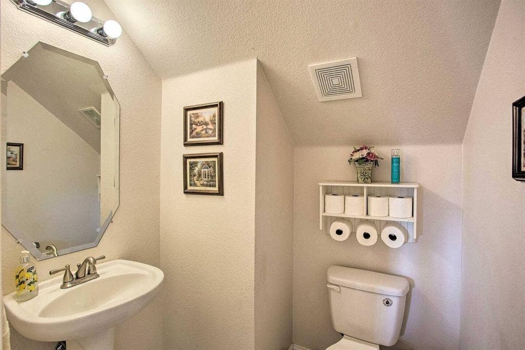 1950 Garrison Way, Garland, TX 75040 Pedestal sink with brushed nickel faucet, octagonal wall mirror, and vanity lighting