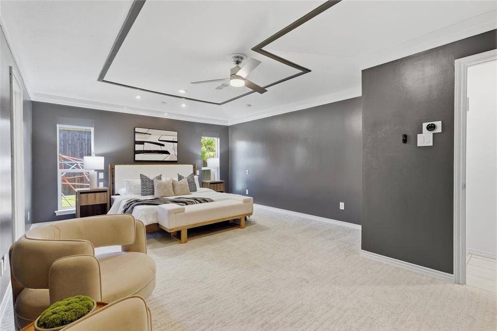 Tray ceiling with accent trim, recessed lighting, ceiling fan, and carpeted flooring