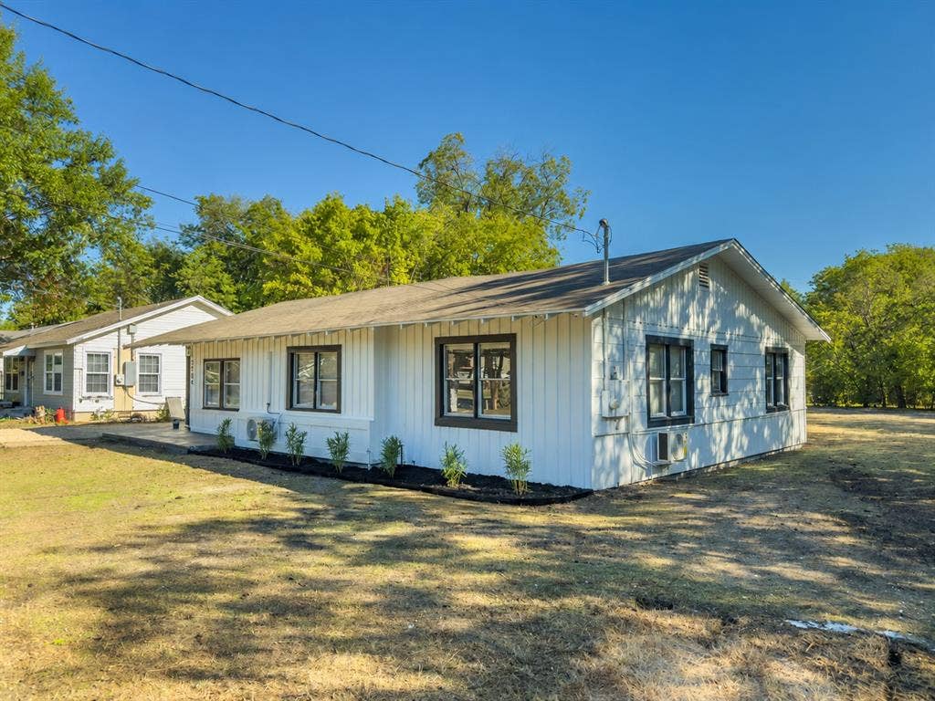 3709 N 22nd Street, Waco, TX 76708 White exterior siding with dark trim windows, front landscaping with dark mulch, and a concrete walkway