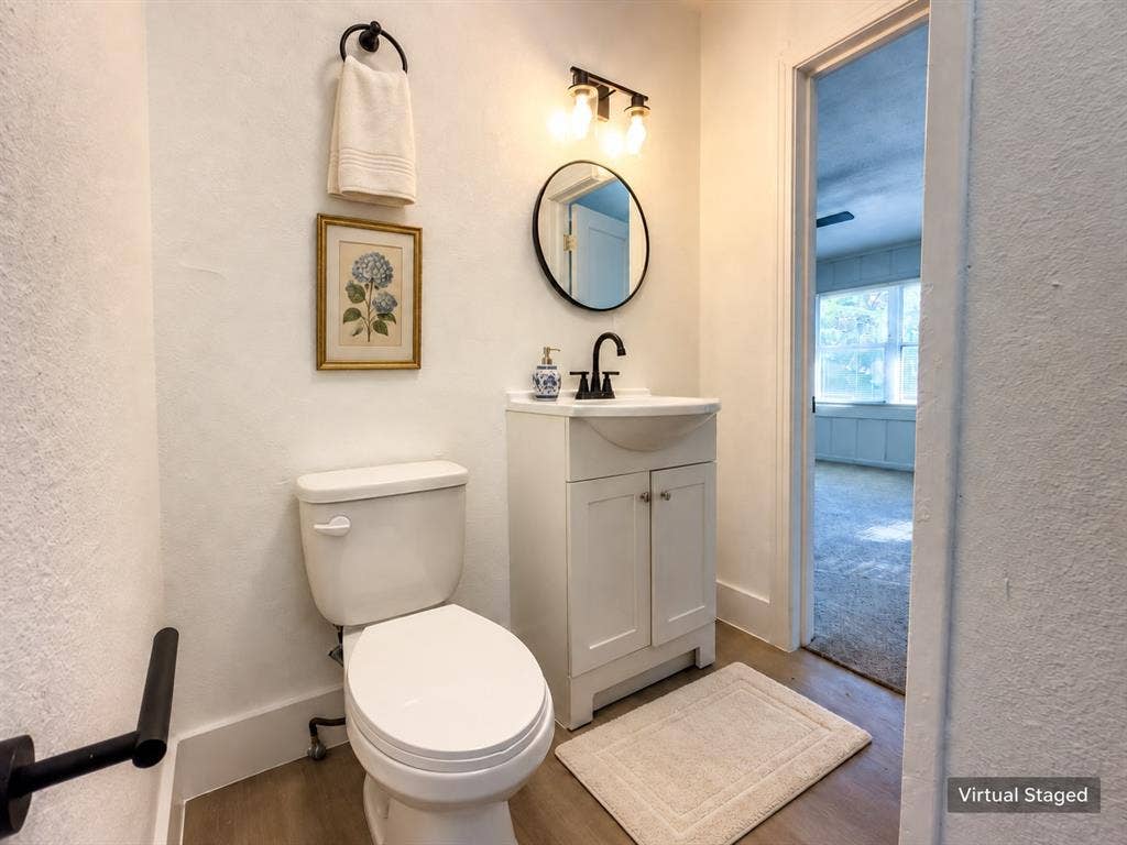 3709 N 22nd Street, Waco, TX 76708 White vanity with cabinet storage, matte black faucet, and coordinating round mirror