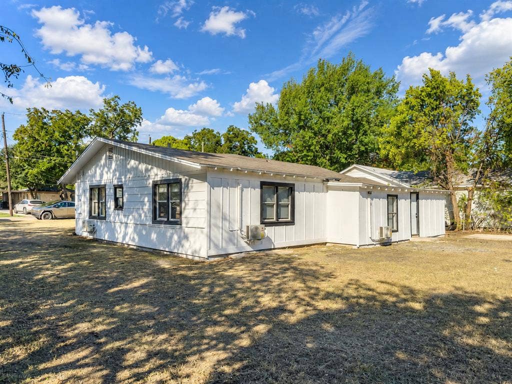 3709 N 22nd Street, Waco, TX 76708 White vertical siding, black-framed windows, and a detached section