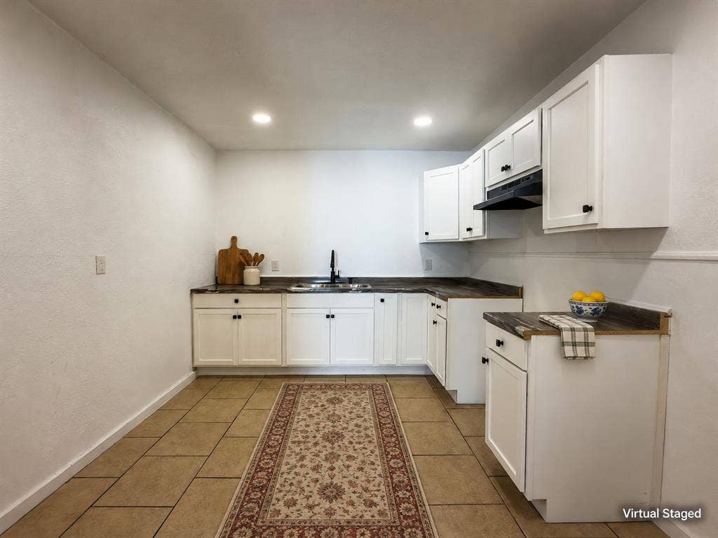 3709 N 22nd Street, Waco, TX 76708 White cabinetry with matte black hardware, dark wood-finish countertops, and a black sink faucet