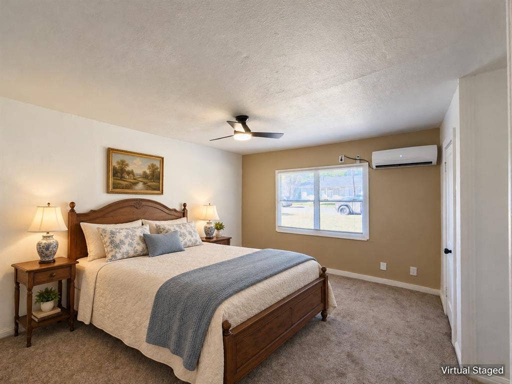 3709 N 22nd Street, Waco, TX 76708 Carpeted room featuring a ceiling fan, window with white trim, and a wall-mounted air conditioning unit