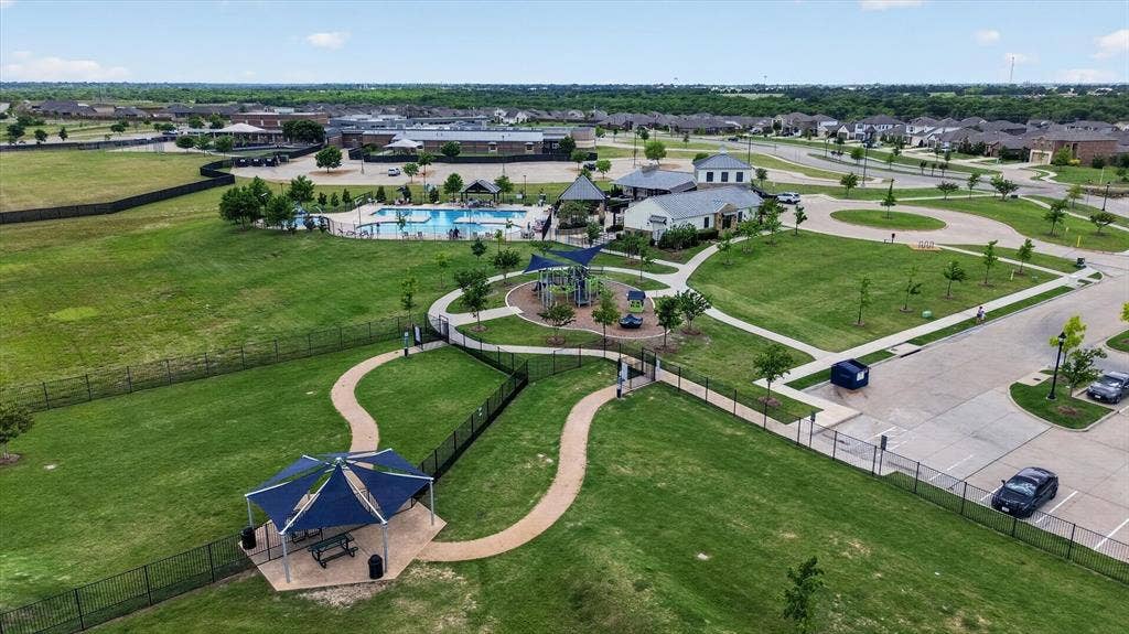 4562 Riverbank Road, Crandall, TX 75114 Expansive green spaces with walking paths, a dedicated playground area, a community swimming pool, and multiple residential structures