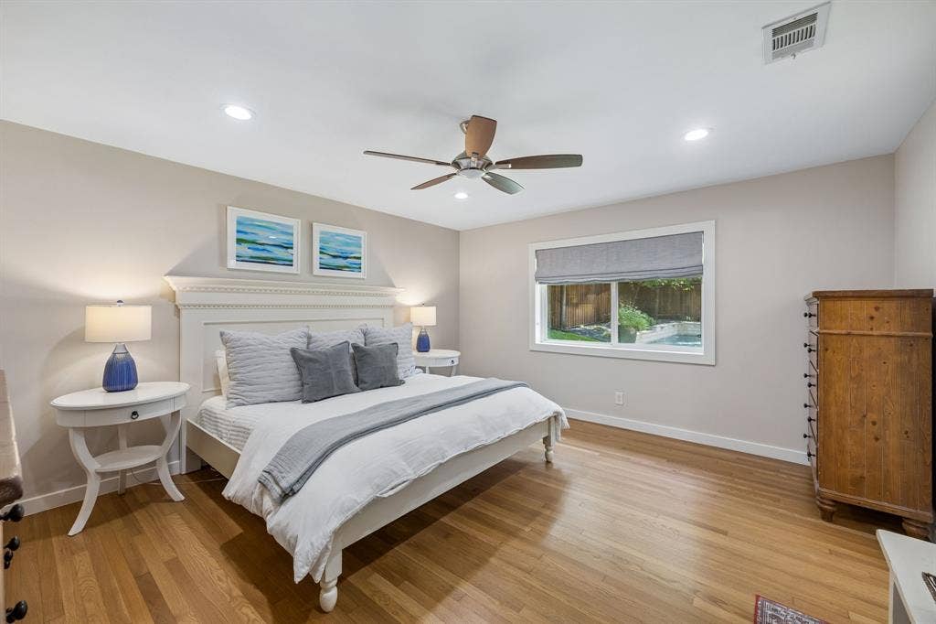 10428 Vinemont, Dallas, TX 75218 Hardwood flooring, recessed lighting, ceiling fan, window with backyard pool visibility, and neutral wall tones