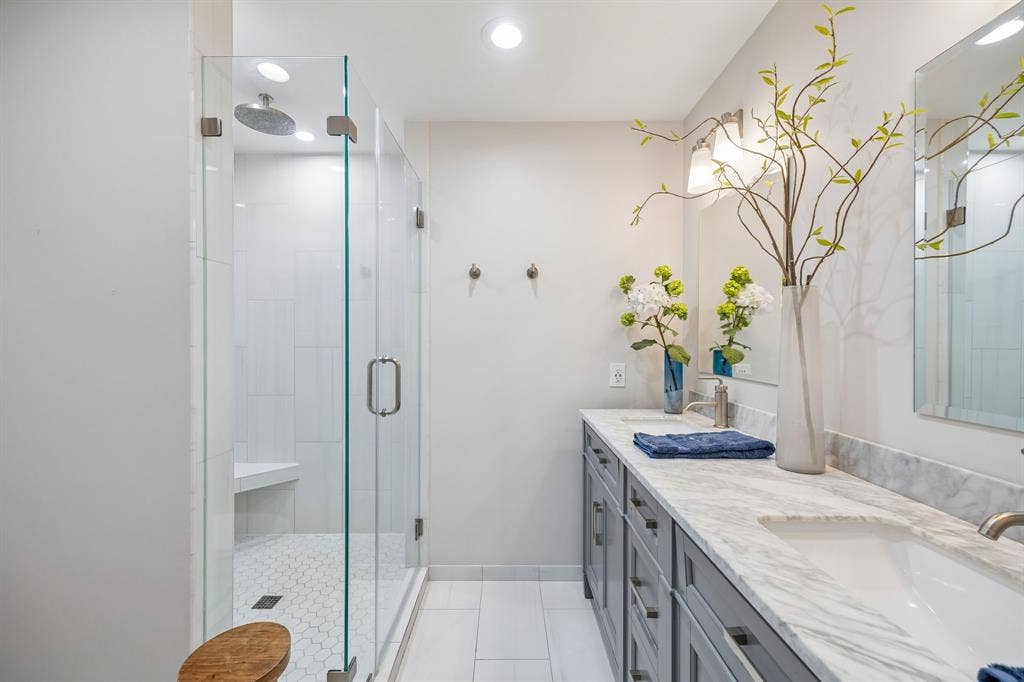10428 Vinemont, Dallas, TX 75218 Glass-enclosed shower with a built-in bench, hexagon tile floor, and ceiling-mounted rain shower head