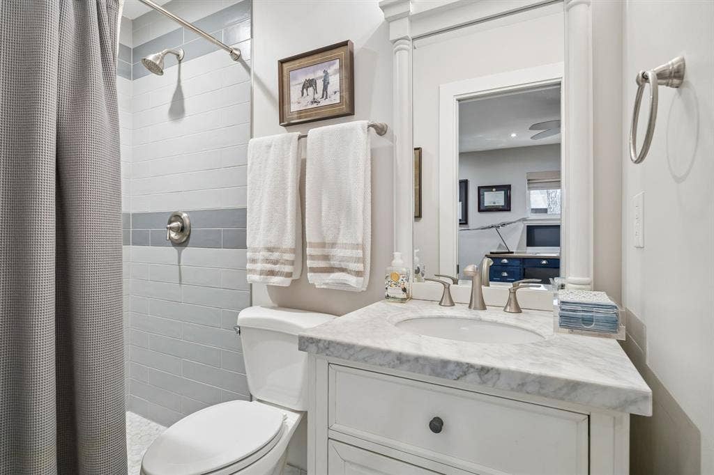 10428 Vinemont, Dallas, TX 75218 Vanity with a marble-finish countertop, undermount sink, and brushed nickel fixtures