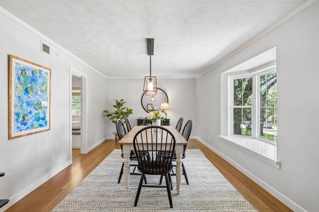 10428 Vinemont, Dallas, TX 75218 Wood-finish flooring, bay window, crown molding, and a modern rectangular chandelier