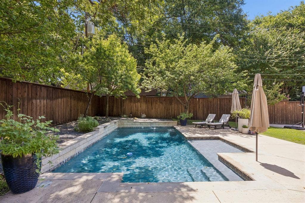 10428 Vinemont, Dallas, TX 75218 Private backyard featuring a swimming pool with integrated steps, concrete surround, and a wooden privacy fence