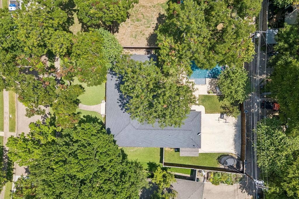 10428 Vinemont, Dallas, TX 75218 Expansive property featuring a grey shingle roof, large concrete patio, and a swimming pool