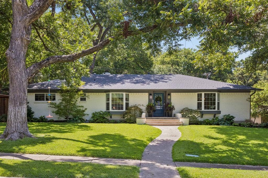 10428 Vinemont, Dallas, TX 75218 White brick exterior with a dark-pitched roof