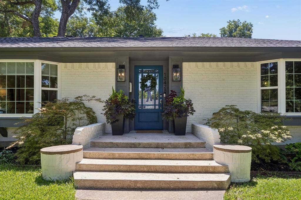 10428 Vinemont, Dallas, TX 75218 White painted brick exterior with a dark-colored roof