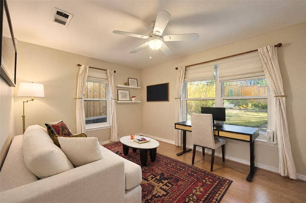 6866 Burwood Lane, Dallas, TX 75214 Wood-finish flooring, multiple windows with neutral window treatments, and a ceiling fan with integrated lighting